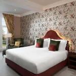 Elegant suite at 12.18. Roxburghe Hotel with floral wallpaper and plush bedding
