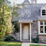 A Scottish cottage at 12.18. Roxburghe Hotel Golf & Spa Ltd., boasting a brick facade with a white door and lush lawn