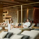 A couple enjoys a luxurious moment in a room with white furniture at Roxburghe Hotel Golf & Spa