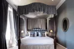 Elegant Junior Suite with canopy bed at 12.18. Roxburghe Hotel, boasting style and impressive estate views.