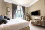 Elegant Castle Deluxe Room at 12.18. Roxburghe Hotel Golf & Spa Ltd with stylish bed, TV, and high-class furnishings.