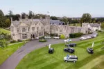 12.18. Roxburghe Hotel with parked cars on lush lawn under clear sky