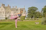Woman practicing yoga in grass field - 12.18. Roxburghe Hotel Golf & Spa Ltd.