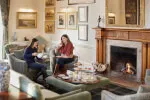 Two women enjoying tea in a cozy living room, indoor ambiance by Roxburghe Hotel Golf & Spa Ltd.