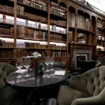 Elegant library bar setting at Roxburghe Hotel with wine glasses on the table, embodying relaxation and sophistication.
