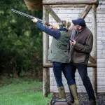 Man and woman engaging in shooting sport at an outdoor range