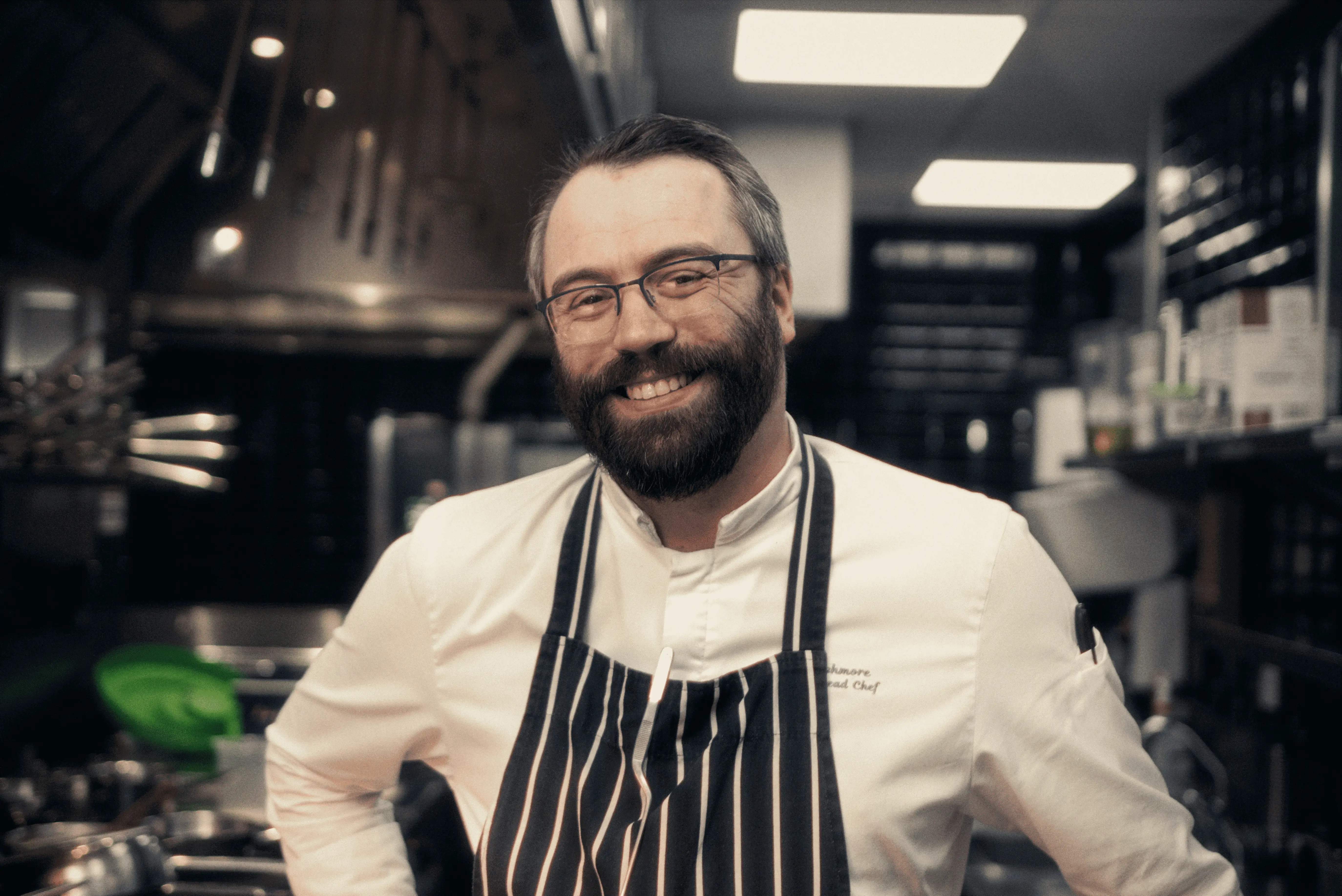Smiling chef in a professional kitchen at Roxburghe Hotel Golf & Spa Ltd.