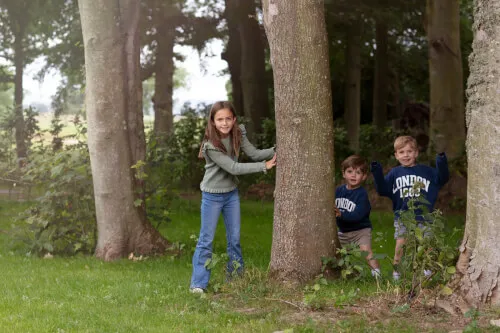 Children playing hide-and-seek in a forest at Roxburghe Hotel Golf & Spa Ltd.