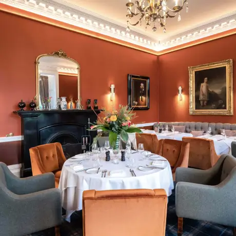 Elegant dining room at Roxburghe Hotel with a round table and art decor.