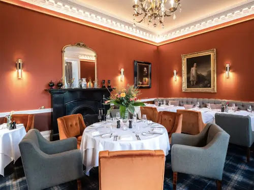 Elegant dining room at Roxburghe Hotel with fine table settings and chandelier.