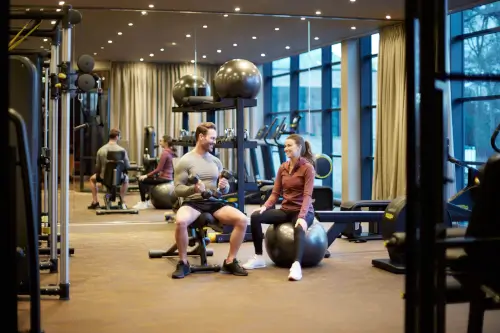 Couple enjoying fitness routine in the Roxburghe Hotel Golf & Spa fitness suite.