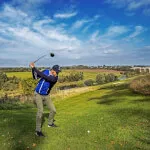 A golfer preparing to swing on a bright day at Roxburghe Hotel Golf & Spa.