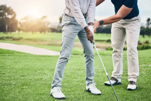 Golf instructor guiding a student on a lush golf course at Roxburghe Hotel Golf & Spa.