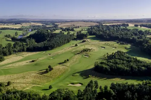 Aerial view of Roxburghe Hotel Golf Course with lush greenery and tree-lined landscapes.