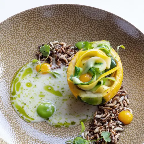 Gourmet dish from Roxburghe Hotel, featuring zucchini, egg yolks, and a green sauce on a decorative plate.