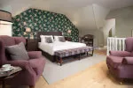 Luxurious bedroom in Roxburghe Hotel featuring floral decor and comfortable seating.