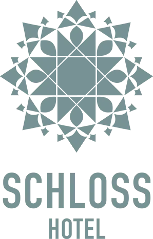 Schloss Hotel logo featuring an elegant floral design.