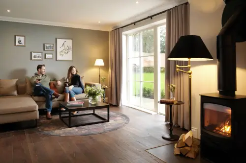 Couple relaxing in a cozy living room at Roxburghe Hotel with a fireplace.