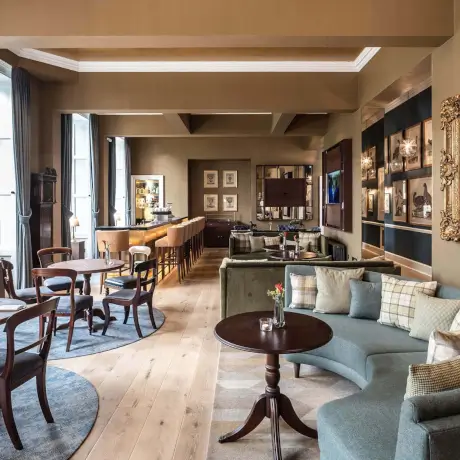 Stylish lounge in Roxburghe Hotel Golf & Spa, featuring elegant furniture and framed artwork.