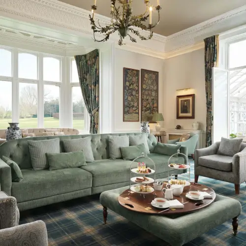 Luxurious lounge with a green sofa and coffee table at Roxburghe Hotel Golf & Spa.