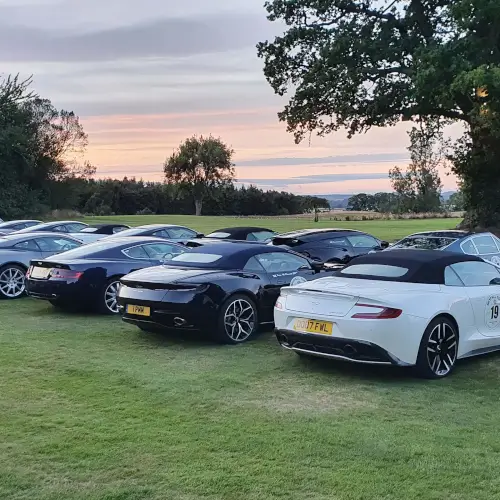 Luxury cars parked on the lawn at Roxburghe Hotel Golf & Spa Ltd. enjoying a beautiful sunset.