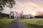 Stunning view of Roxburghe Hotel with lush grounds at sunset.