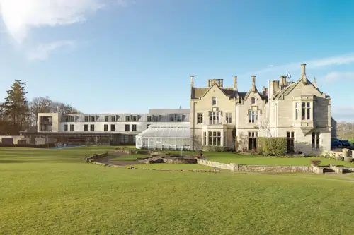 Roxburghe Hotel Golf & Spa with a blend of historic and modern architecture in a lush green landscape.