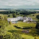 Aerial view of Roxburghe Hotel Golf & Spa surrounded by beautiful landscapes.