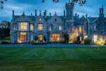 Illuminated facade of Roxburghe Hotel Golf & Spa at dusk showcasing its stunning architecture.