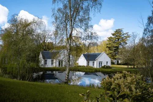 Scenic view of Roxburghe Hotel Golf & Spa amidst nature by the pond.