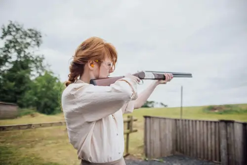 A woman aiming a shotgun at the Country Sports Centre shooting range.