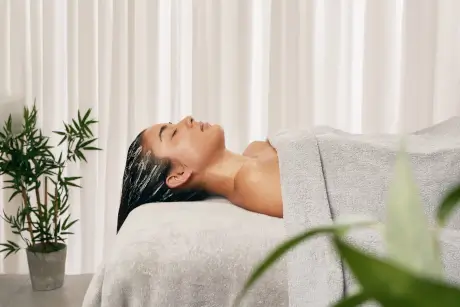 A woman relaxing at Roxburghe Hotel Golf & Spa equipped with serene spa elements.