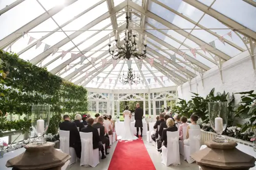 Wedding ceremony in a glass conservatory at Roxburghe Hotel Golf & Spa.